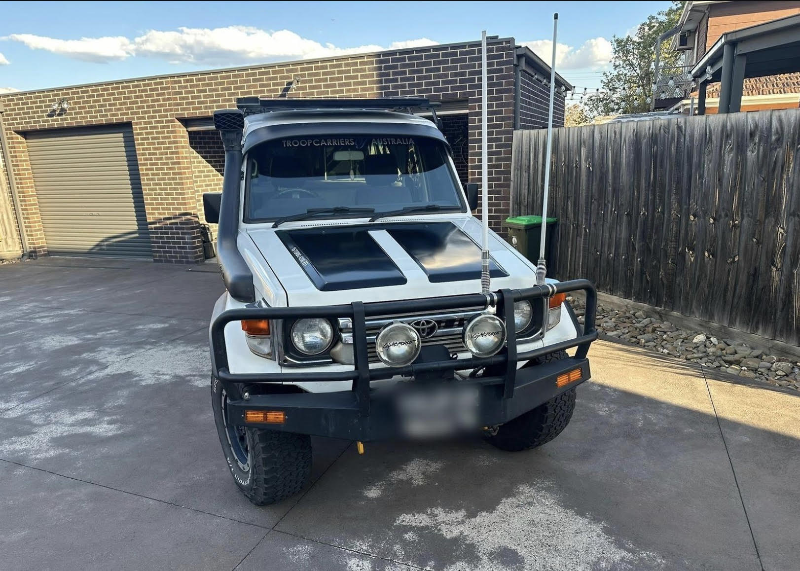 White LC78 Troopy with bull bar and snorkel, front 3/4 view, Australia